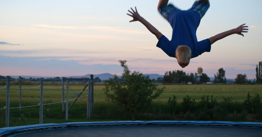 Junge hüpft auf einem ALDI Trampolin und macht dabei einen Salto
