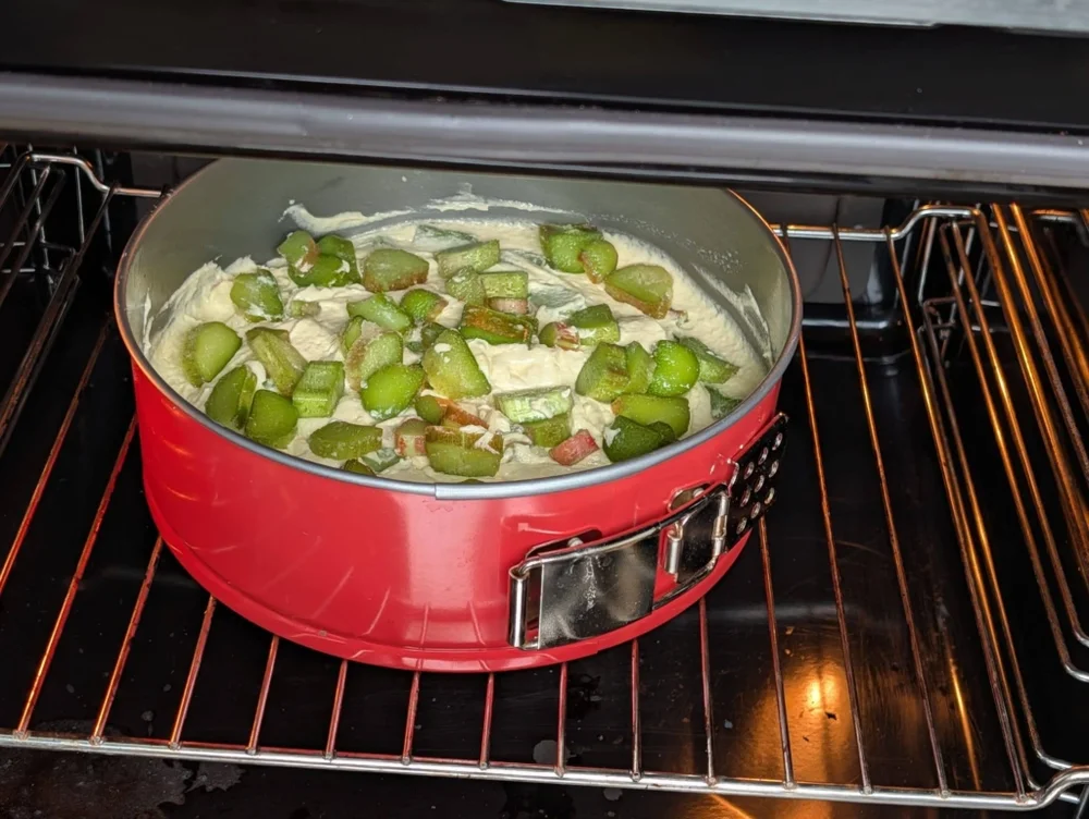 Rhabarberkuchen in roter Form im Ofen